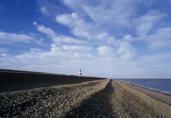 A view along the shingle beach with the Lighthouse in the distance
