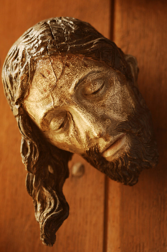 Close view of a wooden head of Christ crucified, in the room called Dragon at Snowshill Manor, part of the extensive collections of Charles Wade