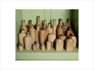 Wicker covered picnic bottles on a shelf in the Butler's sitting room at Tyntesfield