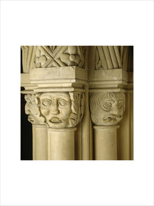 Close-up of a group of three carved limestone capitals between the windows of top landing at Penrhyn Castle