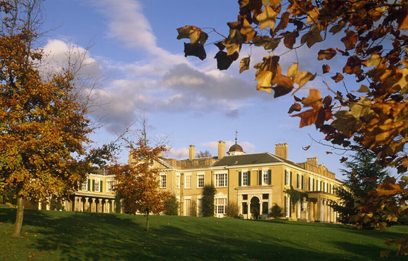 The west face of Polesden Lacey, catching the afternoon sun, with trees in bronze autumn colour in the foreground