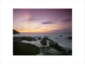 A sunset coastal view taken at the Giant's Causeway, with the sea in motion over the unusual rock formations