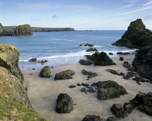 A view looking down into Kynance Cove on the Lizard Peninsula with unusual rocks formations on the sandy beach