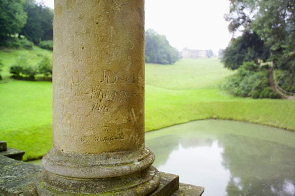 Initials engraved into the columns of the eighteenth-century Palladian Bridge at Prior Park, Bath, UK with the house (not NT) visible in the distance