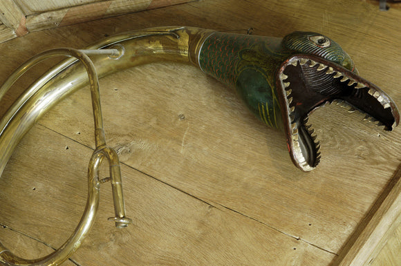 A bell from a buccin trombone, ending in a serpent's head, made in Belgium in the C19th; part of the musical instrument collection of Charles Paget Wade in the Music Room at Snowshill Manor, Gloucestershire