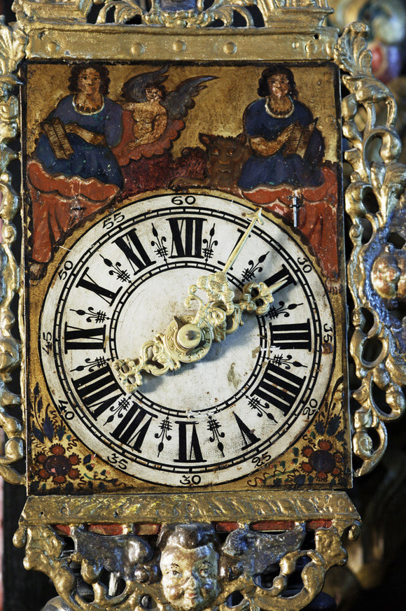 Close view of a clock face, part of the Charles Wade collection at Snowshill Manor, Gloucestershire