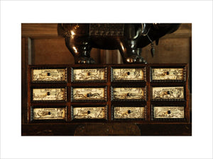 A set of drawers with the months of the year carved on them, part of the Charles Wade collection at Snowshill Manor, Gloucestershire