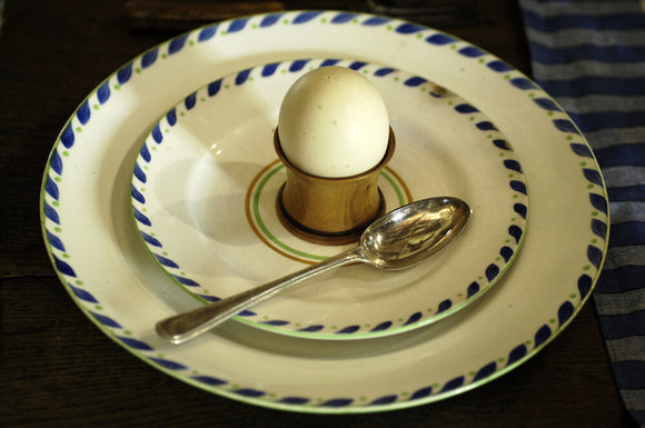 A wooden egg cup on a creamware plate, part of the collection in the Living Room at the Priest's House, Snowshill Manor