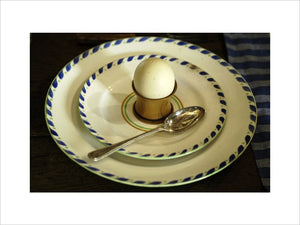 A wooden egg cup on a creamware plate, part of the collection in the Living Room at the Priest's House, Snowshill Manor