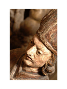 Close view of the head of a carved wooden figure of a bishop, part of the collection in Nadir at Snowshill manor