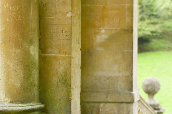 A close view of the C18th columns of the Palladian Bridge at Prior Park, Bath, UK, showing grafitti