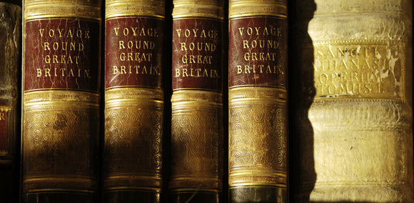 Close view of the spines of a collection of books in Ann's Room at Snowshill Manor