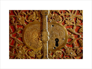 Close view of the lock detail of a French, red lacquered cabinet in the Grey Room at Snowshill Manor