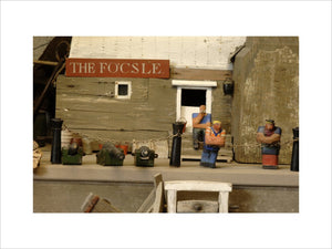 Close view of three wooden figures in front of The Focsle, part of the reconstruction of Wolf's Cove, the model village which was once in the garden at Snowshill Manor but is now in the room known as Occidens