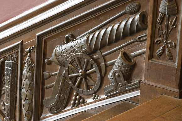 Close view of part of the panelling of the Great Staircase at Ham House, Surrey with the balustrade carved with trophies of war