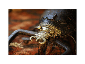 Close view of an iron and brass lockable box in the form of a scorpion, used to store herbal remedies