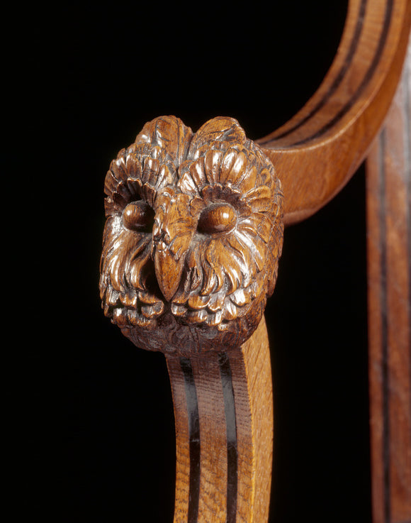 Details of owl mask carved on arm-rest of sabre-leg armchair in the Library of Melford Hall