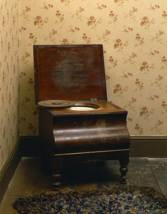 A wooden commode in a 1930s-style bedroom of the Birmingham Back to Backs