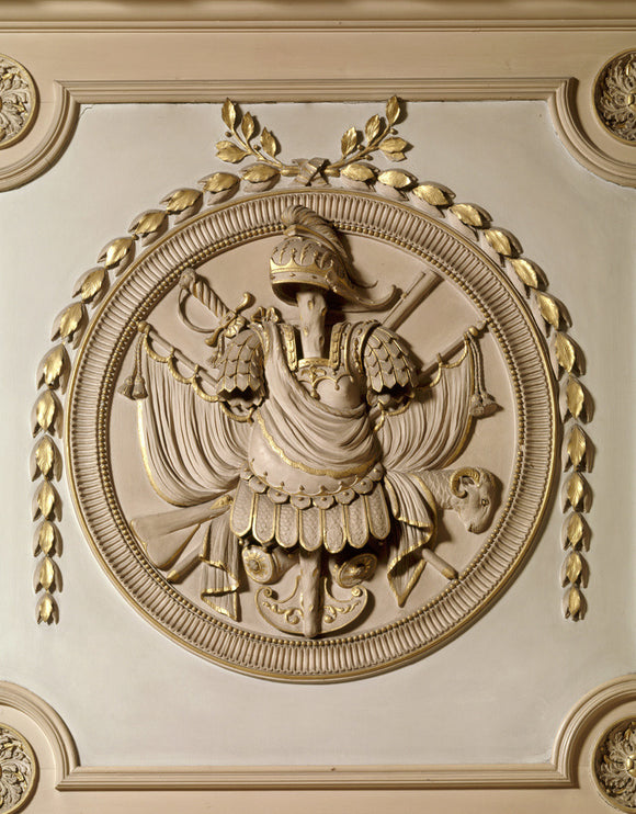 A detail of armorial trophy in roundel above the door in the Marble Hall