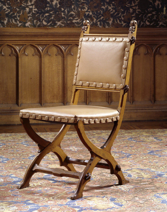 One of a set of four oak X-frame chairs supplied by John G.Crace & Sons, c.1855, at Tyntesfield.