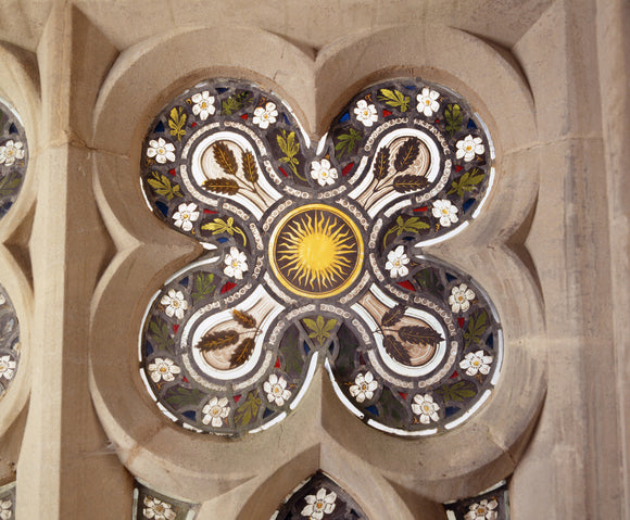 Close view of a quatrefoil stained glass window with sun design in the centre in the Chapel at Tyntesfield