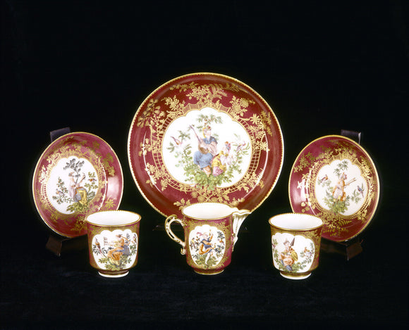 Close view of six pieces from the eighteenth century Chelsea tea service in the French Room at Upton House, decorated with Chinoiserie figures surrounded by gilt trellis work