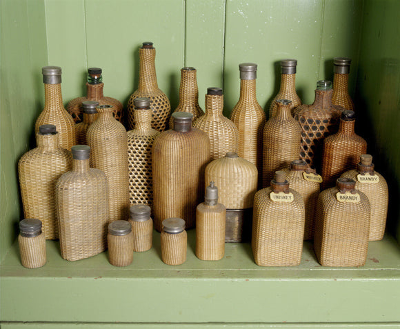 Wicker covered picnic bottles on a shelf in the Butler's sitting room at Tyntesfield