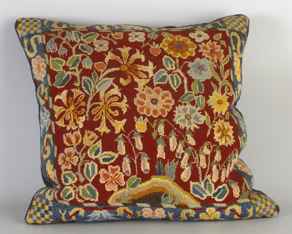 An embroidered cushion in the Drawing Room at Standen, West Sussex, probably worked by Maggie Beale, daughter of Margaret Beale