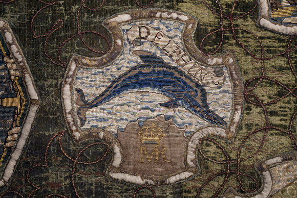 A motif from the Marian Needlework at Oxburgh Hall showing a dolphin with the initials MR