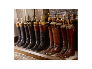 Leather boots lined up in the fireplace of the front stairs at Great Chalfield Manor, near Melksham, Wiltshire