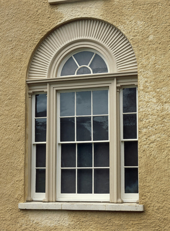 Close view of detail of exterior of Llanerchaeron by John Nash, 1794-96,showing recessed venetian window with carved stone sunray design, carved mullions and slender glazing bars