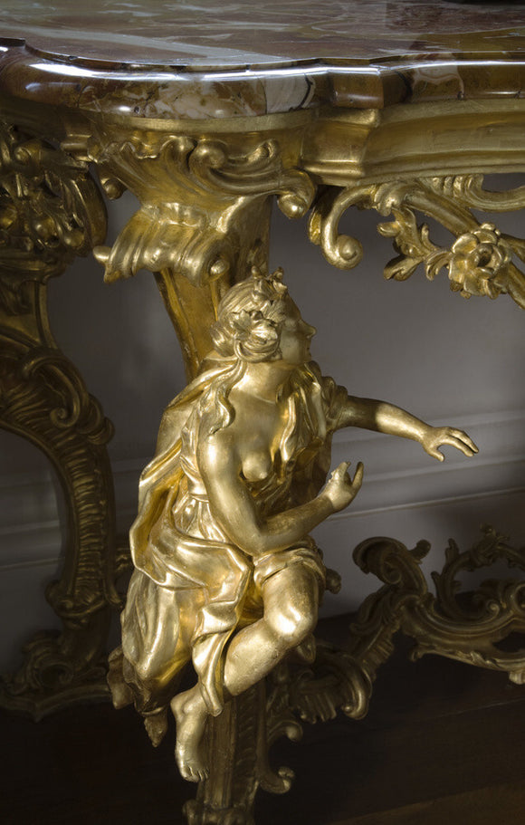 Gilded figure on the leg of a marble topped table on the half-landing of the Staircase at Arlington Court, Devon
