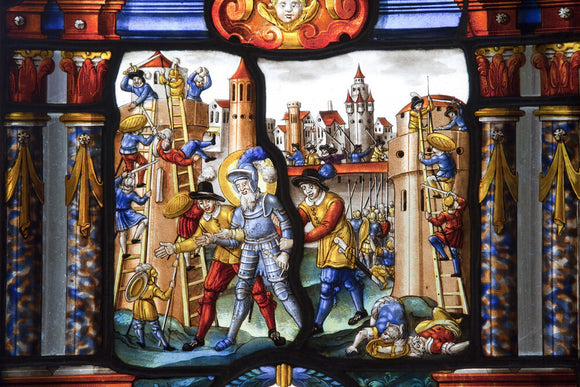 A stained glass panel of the sixteenth or seventeenth century, Swiss-German, with a knight in armour amid a town scene, in the Hall at Upton House, Warwickshire