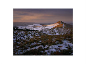 A panoramic view of a snowy Roseberry Common, with the prominent Topping, catching the early morning sun and the horizon lost in the mist