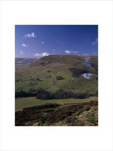 A view of Edale in early spring, snow dusts the side of the hills in shade