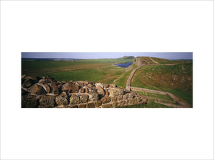 Panoramic view of a milecastle and the continuation of the wall, with Highshield Crags and Crag Lough in the distance