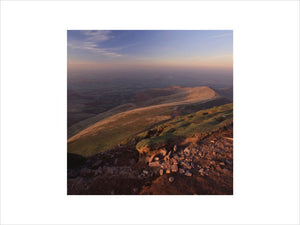A rosy glow lights the ridge of Cefn Cwm Llwch seen to the north from the summit of Pen Y Fan