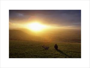 A lone figure, silhouetted by the sunset at Devil's Dyke, South Downs, West Sussex