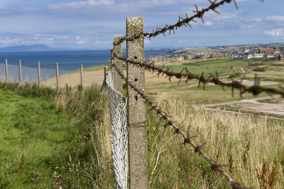 Looking through barbed wire fencing towards Whitehaven, Cumbria