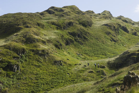 Shepherds appearing as tiny specks on the Snowdonia hillside of the Hafod Y Llan farm