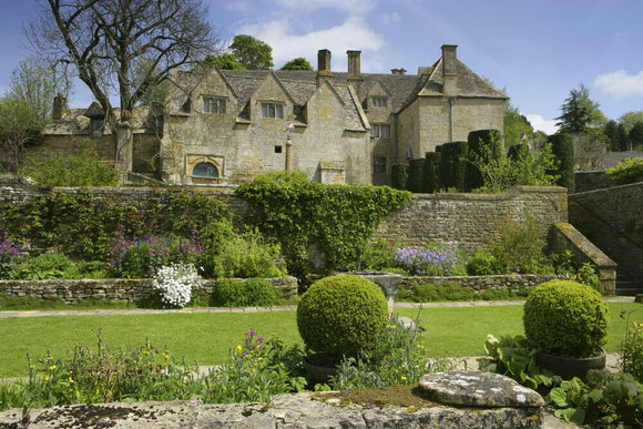 The West front of Snowshill Manor, Gloucestershire, UK with the garden and terrace in the foreground