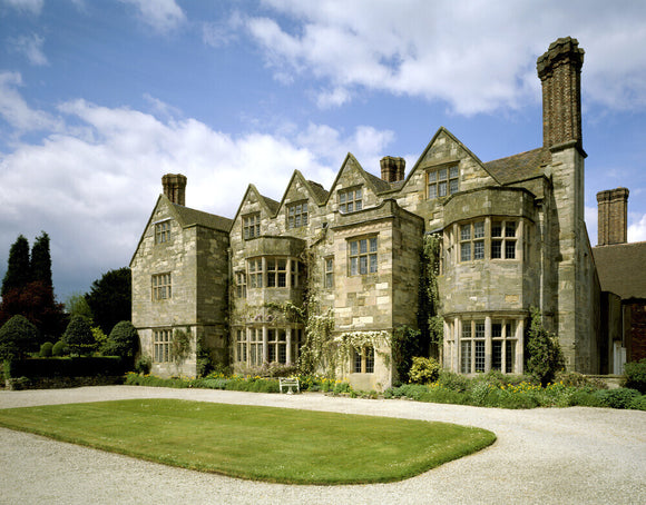 The garden front of Benthall Hall, a 16th century stone house, with a grassy forecourt