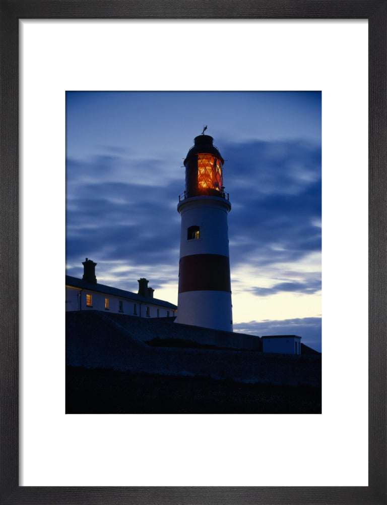 The Lighthouse at Souter showing a red light at dusk, against a dramat ...