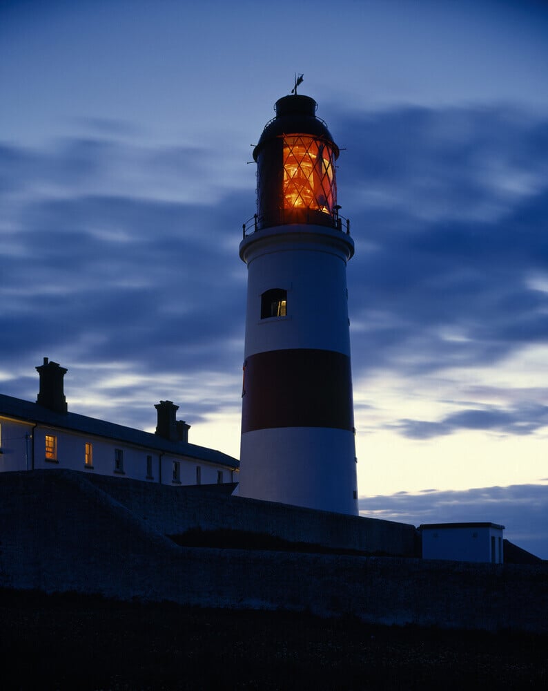 The Lighthouse at Souter showing a red light at dusk, against a dramat ...
