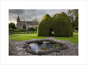 The C14th century Paris Church of All Saints, seen across the lily pond at Great Chalfield Manor, Wiltshire
