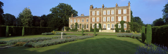 Nearer oblique view of the front of Gunby Hall showing lawns and lavender beds with a sundial