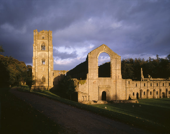 Spotlights light up part of Fountains Abbey and the Cellarium at dusk