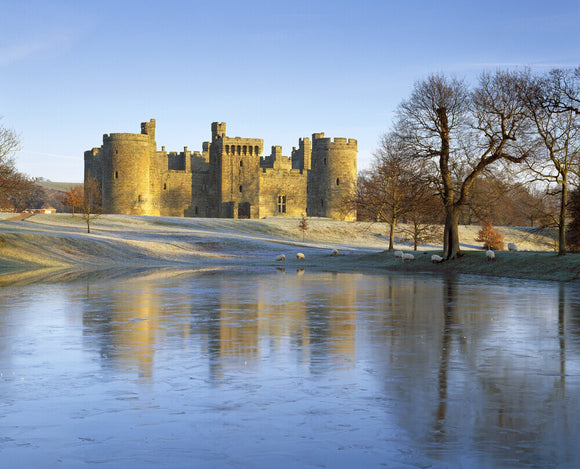 A wintry view of Bodiam Castle with a light dusting of snow on the ground