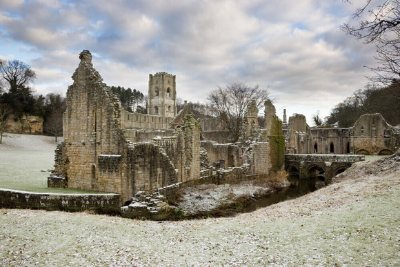 The ruins of the East Guest House with the Tower of Fountains Abbey behind it
