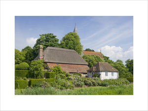 A view towards the back of Alfriston Clergy House, a fourteenth-century Wealden hall house in a cottage style garden in East Sussex